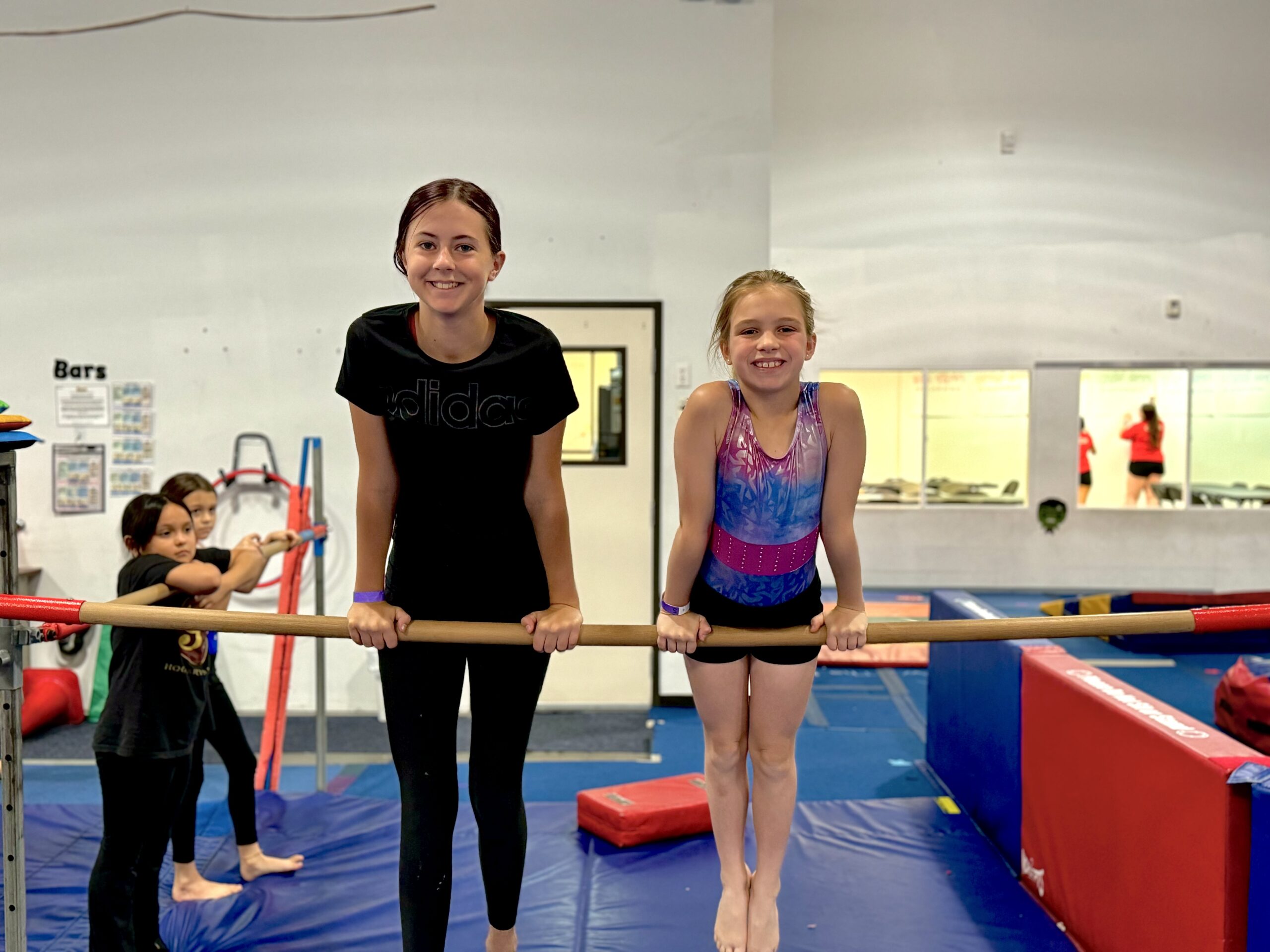 young girl hanging on gymnastics bars